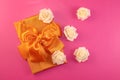 Gift box with rose flowers on pink background. flat lay