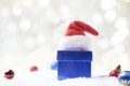 Gift box , Santa hat and Christmas balls in snow on abstract background. Royalty Free Stock Photo