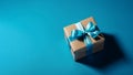 Gift box with satin ribbon and bow on blue background. Holiday gift with copy space. Birthday or Christmas present, flat lay, top Royalty Free Stock Photo
