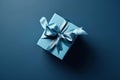 Gift box with satin ribbon and bow on blue background. Holiday gift with copy space. Birthday or Christmas present, flat lay, top Royalty Free Stock Photo