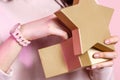 Gift box in the shape of a gold star in the hands of a young Asian girl. on a pink isolated background