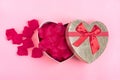 Gift box in the shape of a heart with rose petals inside on a pink background Happy Valentine`s day concept. Royalty Free Stock Photo