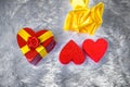 Gift box in the shape of a heart tied with a yellow ribbon with a bow in the shape of a rose lies on the pillow fake fur and next Royalty Free Stock Photo