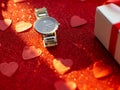 Gift box and silver watch is on red heart paper background