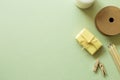 Gift box, string roll, wooden pencils, clips on green background