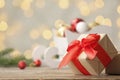 Gift box on table against blurred Christmas lights. Royalty Free Stock Photo