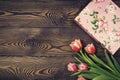 Gift box and tulip flowers on rustic table for March 8, International Womens day, Birthday or Mothers day, beautiful spring card Royalty Free Stock Photo