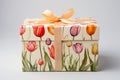 Gift box with watercolor tulips on it. Gift adorned with a ribbon. Perfect for Woman's Day, Motherâs Day, birthday