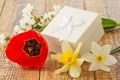 Gift box on wooden boards with flowers of daffodils, tulip and jasmine