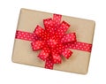 Gift box wrapped in brown recycled paper with red polka dot ribbon bow top view isolated on white background, clipping path Royalty Free Stock Photo