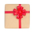 Gift box wrapped in brown recycled paper with red polka dot ribbon bow top view isolated on white background, clipping path Royalty Free Stock Photo