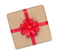 Gift box wrapped in brown recycled paper with red polka dot ribbon bow top view isolated on white background, clipping path Royalty Free Stock Photo