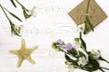 Gift box wrapped in craft paper, flower and starfish on a white table top. Flat lay. Copy space for text Royalty Free Stock Photo