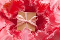 Gift box wrapped with craft paper and pink bow in pink tulip flowers. Holiday concept Royalty Free Stock Photo