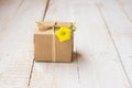 Gift box wrapped in craft paper tied with twine, spring yellow flower Royalty Free Stock Photo