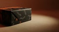 Gift box wrapped in dark patterned paper with orange accents Royalty Free Stock Photo