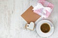 Gift box wrapped in pink dotted paper, heart shaped love cookie, a cup of coffee and an empty kraft card over a white wood Royalty Free Stock Photo