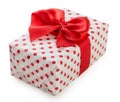 Gift box wrapped in white paper with red dots and bright red ribbon bow isolated on a white background Royalty Free Stock Photo