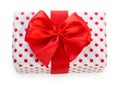 Gift box wrapped in white paper with red dots and bright red ribbon bow. Isolated on a white background, top view Royalty Free Stock Photo