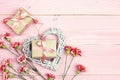 Gift boxes with carnations flowers on pink wooden background. Copy space. Royalty Free Stock Photo