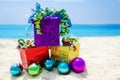 Gift boxes with Christmas balls on the beach - holiday concept Royalty Free Stock Photo