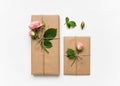 Gift boxes in eco paper on white background. Presents decorated with roses. Holiday concept, top view, flat lay Royalty Free Stock Photo