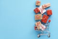 Gift boxes flying out of a shopping cart on black background