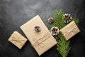 Gift boxes and green Christmas tree branch with pine cone on dark background Royalty Free Stock Photo