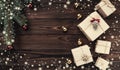 Gift boxes over dark wooden background. Fir tree with baubles, space for text. Top view. Effect snowflakes Royalty Free Stock Photo