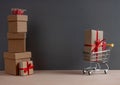 Gift boxes piles and shopping cart on dark background