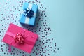 Gift boxes and shiny confetti on light blue background, flat lay. Space for text Royalty Free Stock Photo