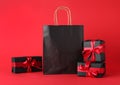 Gift boxes and shopping bag on red background. Black Friday sale Royalty Free Stock Photo