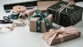 Gift boxes tied with beautiful ribbons with pattern stars with bow.Rolls wrapping paper,ribbons,rope,scissors,cones,red balls