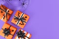 Gift boxes with traditional Halloween event colors orange, black and white and small bats and pumpkins and spider