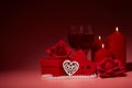 Gift boxes, two glasses with wine, burning candles, red roses and hearts on red background. Valentine`s day. Wedding day Royalty Free Stock Photo