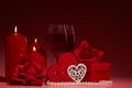 Gift boxes, two glasses with wine, burning candles, red roses and hearts on red background. Valentine`s day. Wedding day Royalty Free Stock Photo