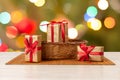 Gift boxes and a wicker basket with blurred twinkling party lights Royalty Free Stock Photo