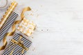 Gift boxes wrapped in black and white striped and golden dotted paper and wrapping materials on a white wood old background. Empty Royalty Free Stock Photo