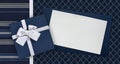 Gift card and gift box with ribbon and bow isolated on elegant blue fabrics background, top view and copy space template, useful Royalty Free Stock Photo