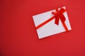 Gift card on red background with red ribbon bow Gift voucher on red background top view copy space Royalty Free Stock Photo