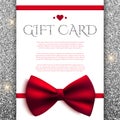 Gift card with red bow on silver glitter background Royalty Free Stock Photo