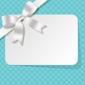 Gift card with white pearl ribbon on a turquoise polka dot background.