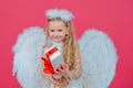 Gift child emotions. Cute angel child girl with angels wings, isolated on red. Valentines day. Playful angelic little Royalty Free Stock Photo