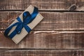 Gift craft box with a blue ribbon on a wooden background. Father`s day. Gift for a man. Royalty Free Stock Photo