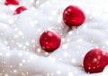 Red Christmas baubles on fluffy fur with snow glitter, luxury winter holiday design background Royalty Free Stock Photo