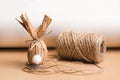 Gift Easter egg in brown craft paper in the shape of a rabbit and a skein of jute threads