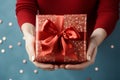 Gift elegance Womans hands holding a red gift with ribbon