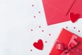 Gift, envelope and red heart on white table for greeting on Valentines Day. Flat lay.