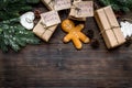 Gift exchange. Boxes with note Santa Secret near spruce branch and gingerbread cookies on dark wooden background top