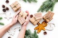 Gift exchange. Hands hold box with note Santa Secret near spruce branch and christmas cookies on white background top